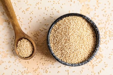 Beyaz arka planda sağlıklı kinoalı kase ve kaşık.