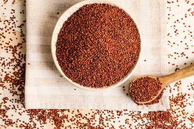 Beyaz arka planda sağlıklı kinoalı kase ve kaşık.