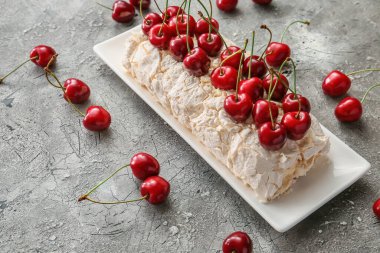 Gri arka planda kirazlı lezzetli kremalı pasta.