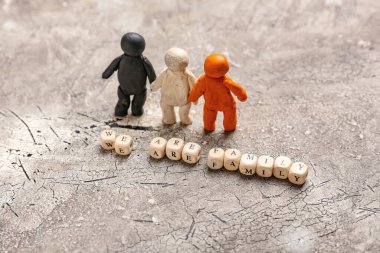 Plastikten ve küplerden yapılmış insan figürleri gri arka planda aşinayız. Irkçılık kavramı