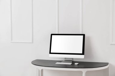 Işık duvarının yanındaki masada modern PC monitörü