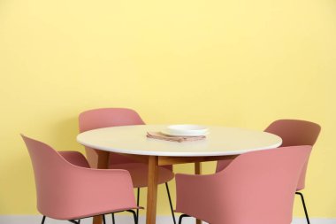 Yemek masası renk duvarının yanında.