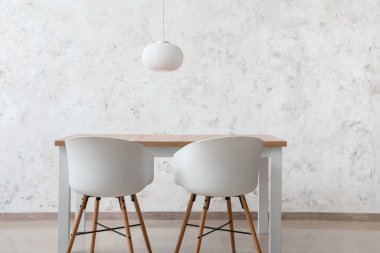 Işık duvarının yanındaki yemek masasında.