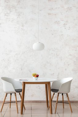 Açık duvarın yanında meyveli yemek masası.