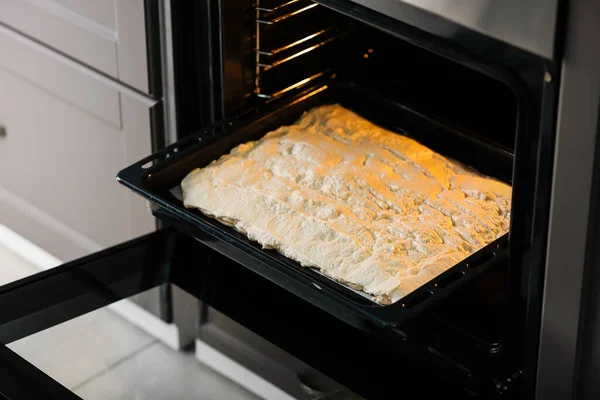 Baking sheet with meringue in oven