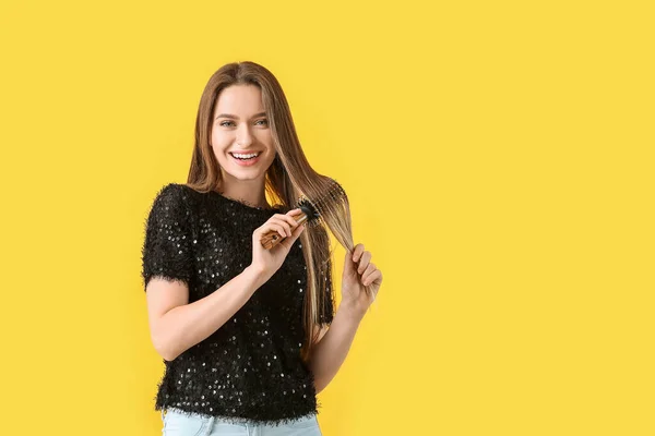 Молодая Женщина Расчесывает Волосы Цветном Фоне — стоковое фото