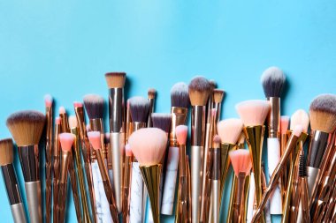 Renk arkaplanındaki makyaj fırçaları