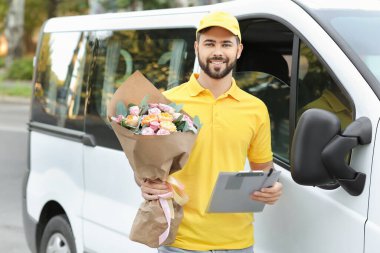 Dışarıdaki arabanın yanında bir buket güzel çiçekle teslimatçı.