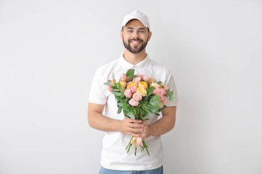 Hafif arka planda bir buket çiçekli teslimatçı.