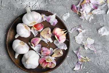 Gri arka planda taze sarımsaklı tabak.