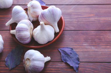 Ahşap zemin üzerinde taze sarımsaklı tabak.