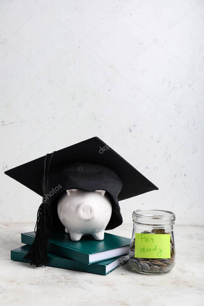 Jar with coins, piggy bank, books and graduation hat on table. Tuition fees concept