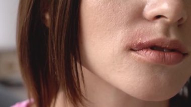 Genç bir kadın dudağına dokunuyor, yakından.