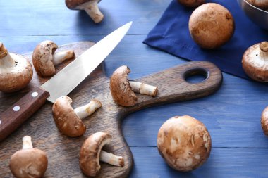 Masada çiğ mantar ve bıçakla tahta kesmek.