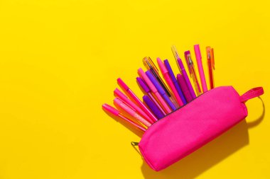 Renk arkaplanında kalemler ve işaretleyiciler olan dosya