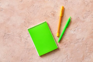 Renk arkaplanı üzerine dizüstü bilgisayarlar ve kalemler