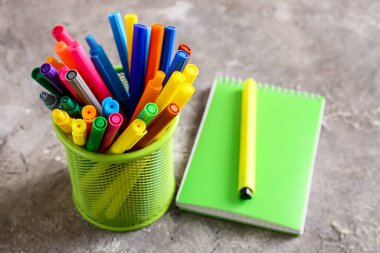 Not defteri, renkli kalemler ve kalemler masaya.