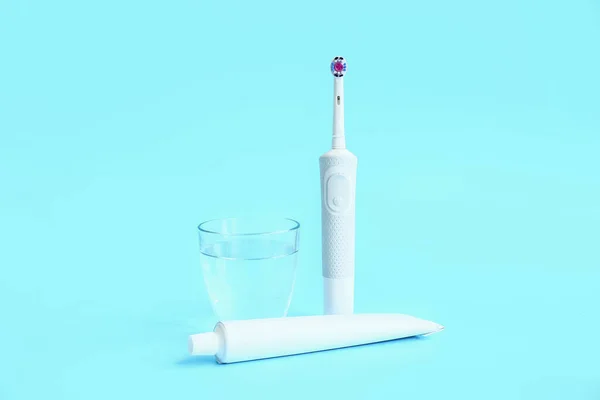 Elektrisk Tandborste Glas Vatten Och Klistra Färg Bakgrund — Stockfoto