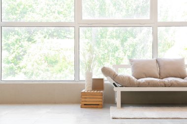 Odanın penceresinin yanındaki modern kanepe