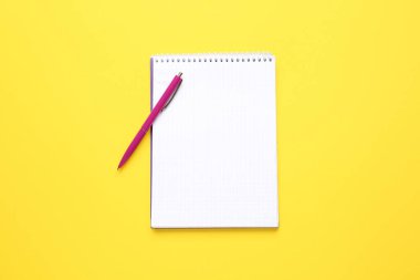 Renk arkaplanı üzerine not defteri ve kalem
