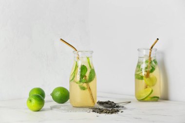 Beyaz arka planda lezzetli soğuk buzlu çay şişeleri