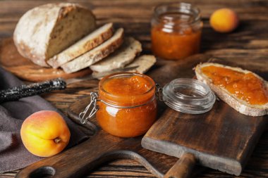 Bir kavanoz lezzetli kayısı reçeli ve ekmek.