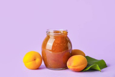 Renkli arka planda lezzetli kayısı reçeli kavanozu