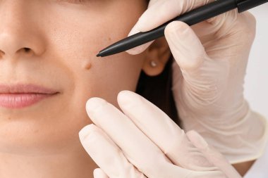 Dermatolog klinikteki hastayı muayene ediyor.