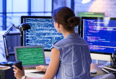 Geceleri ofiste çalışan kadın programcı.