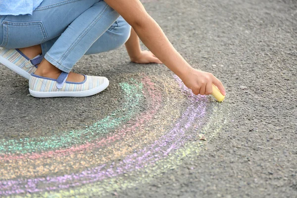 Kleines Mädchen Zeichnet Regenbogen Mit Kreide Auf Asphalt — Stockfoto