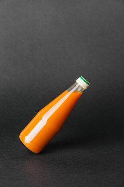 Karanlık arka planda bir şişe meyve suyu.