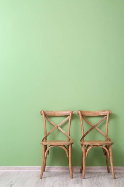 Renkli duvarın yanındaki tahta sandalyeler.