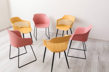 Psikologların ofisinde grup terapisi için hazırlanmış boş sandalyeler.