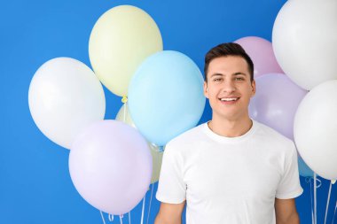 Renkli balonları olan genç bir adam