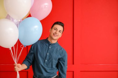 Renkli balonları olan genç bir adam