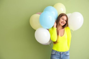 Renkli balonları olan genç bir kadın.