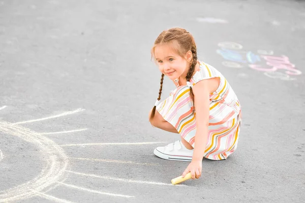 Kleines Mädchen Zeichnet Mit Kreide Auf Asphalt — Stockfoto