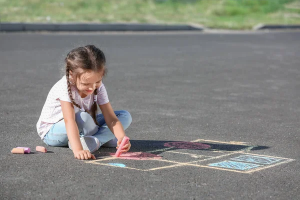 Kleines Mädchen Zeichnet Mit Kreide Auf Asphalt — Stockfoto