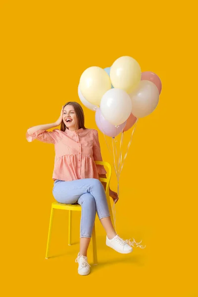 Νεαρή Γυναίκα Μπαλόνια Κάθεται Καρέκλα Φόντο Χρώμα — Φωτογραφία Αρχείου