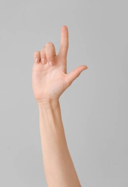 Gri arkaplanda L harfi görünüyor. İşaret dili alfabesi