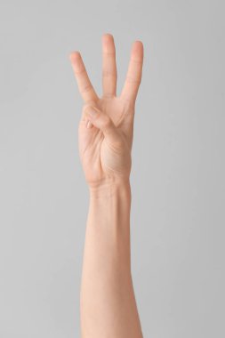 Gri arkaplanda W harfi görünüyor. İşaret dili alfabesi