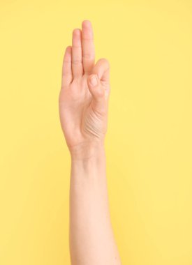 Renk arkaplanında F harfi görünüyor. İşaret dili alfabesi