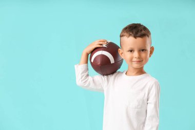 Arka planda rugby topu olan küçük çocuk