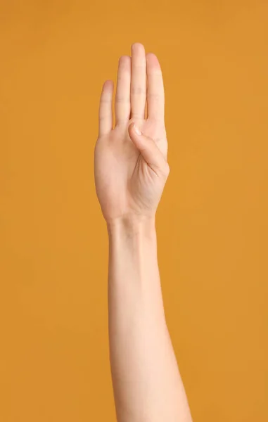 Hand showing letter B on color background. Sign language alphabet