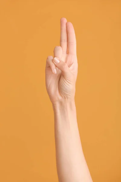 Hand showing letter U on color background. Sign language alphabet