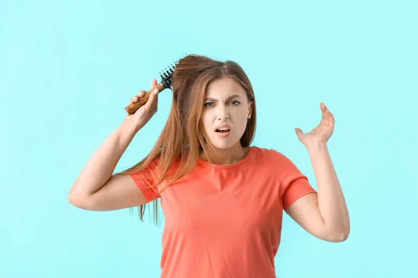 Gestresste Frau Bürstet Haare Auf Farbigem Hintergrund — Stockfoto