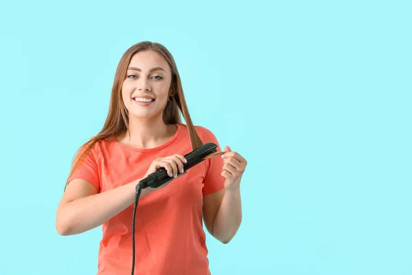 Young Woman Straightening Iron Color Background — Stock Photo, Image