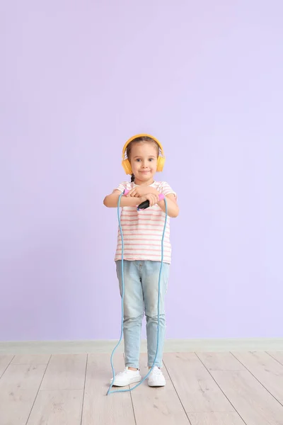 Милая Маленькая Девочка Наушниках Прыгает Канат Цветном Фоне — стоковое фото
