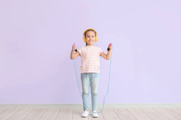 Χαριτωμένο Κοριτσάκι Ακουστικά Άλμα Σχοινί Κατά Φόντο Χρώμα — Φωτογραφία Αρχείου
