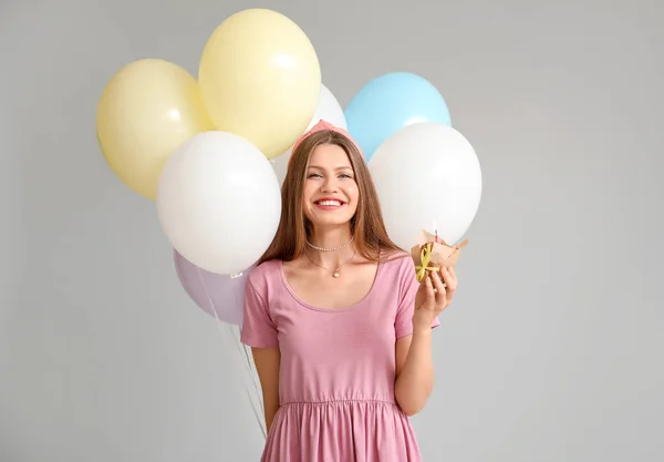 Νεαρή Γυναίκα Μπαλόνια Και Τούρτα Γενεθλίων Γκρι Φόντο — Φωτογραφία Αρχείου